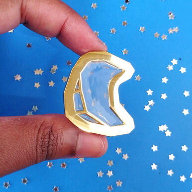 glass moon an transparent enamel pin depicting a stylized moon.